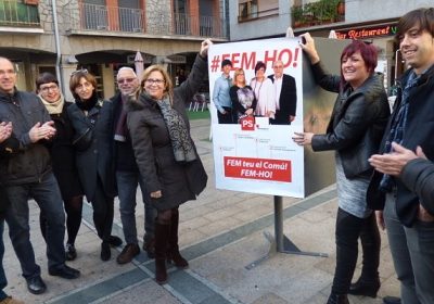 Dolors Carmona i Lídia Samarra enganxen el cartell a la plaça Guillemó