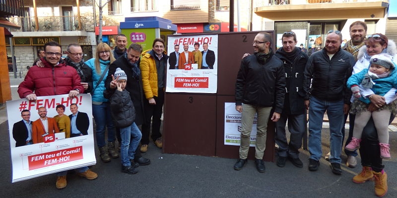 La candidatura d'Encamp al costat del primer cartell enganxat a la plaça del Consell